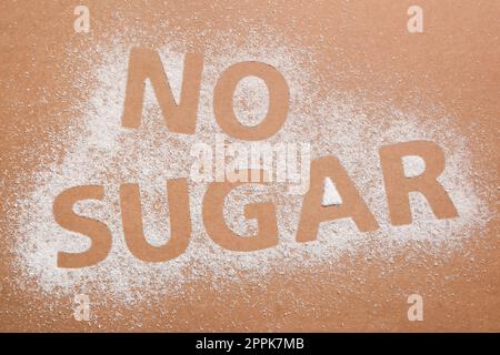 Phrase No Sugar made of granules on brown background, flat lay Stock Photo
