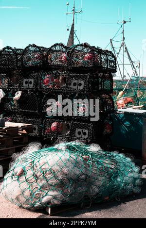 Fishing nets stacked on the pier in a harbour, close-up background fisherman net and boat Stock Photo