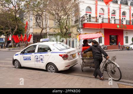 A taxi and a bicycle in Hanoi, Vietnam Stock Photo