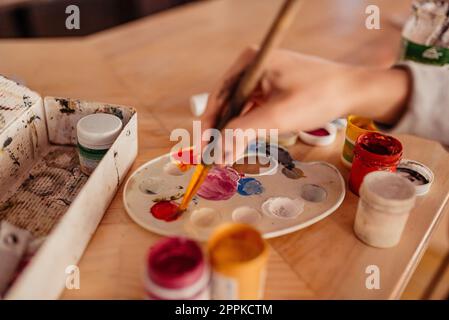 Artist paint brushes and palette on wooden background Stock Photo