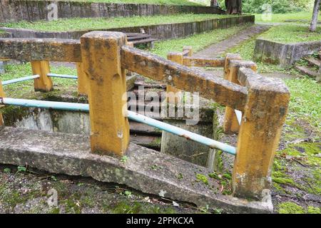 Banja Koviljaca, Loznica, Serbia. Mount Guchevo, park and forest. Source of mineral sulfuric and ferruginous water Rakina Chesma Cesma. A spring near the road to Guchevo. Concrete fence and stairs. Stock Photo