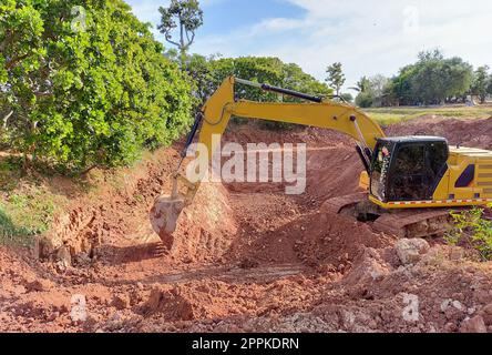 Backhoe bucket digging the soil at agriculture farm to make pond. Crawler excavator digging at shale layer. Excavating machine. Earth moving equipment. Excavation vehicle. Construction business. Stock Photo