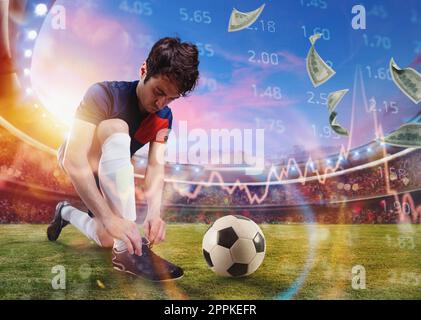 Soccer player ties his football shoes ready to play at the stadium. Online soccer bet Stock Photo