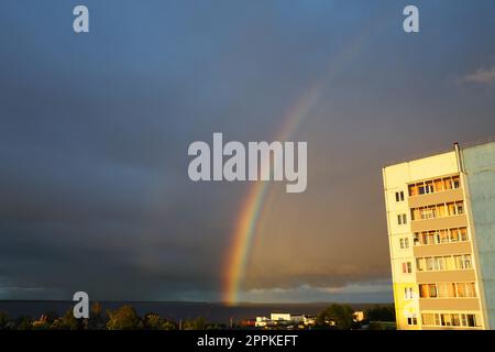 Petrozavodsk, Klyuchevaya district, Karelia, Russia, July 30, 2022. Double multi-colored rainbow over an apartment building. Rain and dark clouds over Lake Onega. Golden hour, blind rain, sun rays Stock Photo