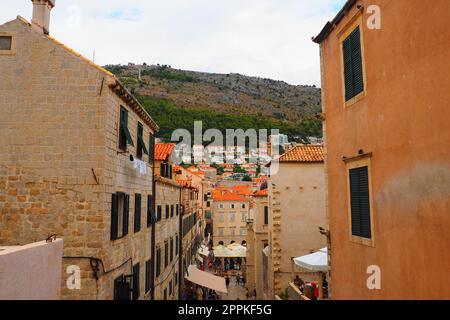 Dubrovnik, Croatia, 08.14. 2022. Narrow streets of the ancient town. The facades of the houses are made of marble and stone very close to each other. Windows with shutters. Summer tourism in Adriatic. Stock Photo