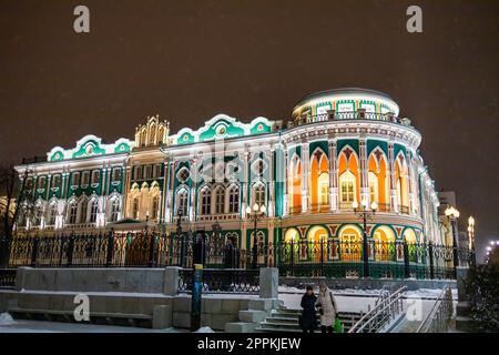 YEKATERINBURG, December 18, 2021: Sevastyanov House also House of Trade Unions in Yekaterinburg in Russia at night and winter season. Its a palace built in the first quarter of XIX century on the banks of the city pond, formed by a dam on the Iset River. Stock Photo