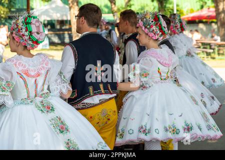 Rakvice, Czech Republic - June 2021. Beautiful women and men dancers in a celebration.Traditional Moravian feast. Young people in parade dressed in traditional Moravian folk costume. Stock Photo