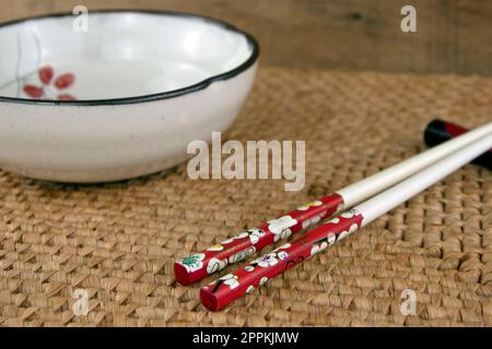 Minimalist scene of empty white bowl and chopsticks, side view Stock Photo