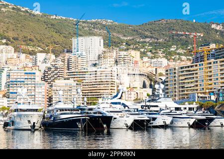 Monte Carlo, Monaco - Port Hercule with luxury yachts,  boats, and scenery skyline Stock Photo