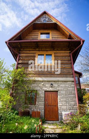 Old wooden cottage in a valley on a hill, beautiful blue sky. Landscaping. Travel, vacation. Stock Photo