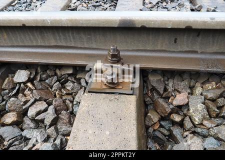 Railways. Metal steel rails and wooden sleepers. Rivets and fasteners on the railroad. Stony backfill of railway tracks. Station Nyrki, Karelia. Stock Photo