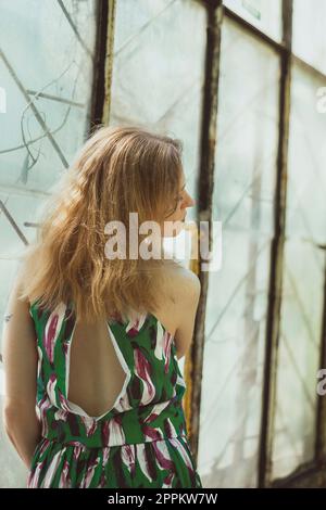 Pretty lady from behind standing by window scenic photography Stock Photo