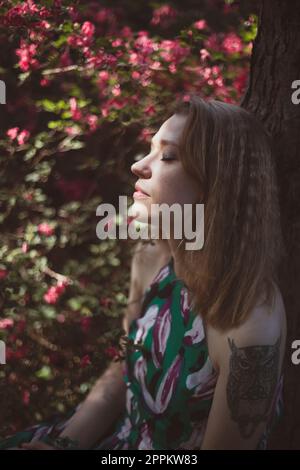 Close up woman resting with closed eyes in garden portrait picture Stock Photo