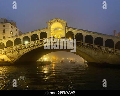 illuminated Rialto Bridge in night winter fog Stock Photo