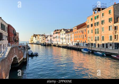 apartment buildings on canal lit by sun in Venice Stock Photo