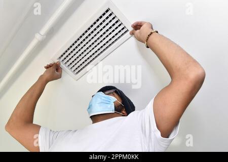 Man installing air conditioner in a house - France Stock Photo
