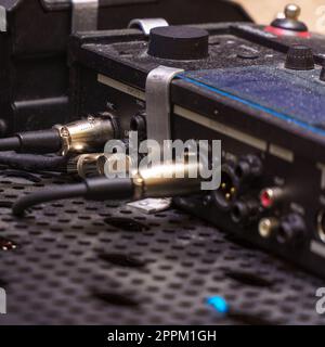Audio jacks are plugged into a guitar synthesizer or processor Stock Photo