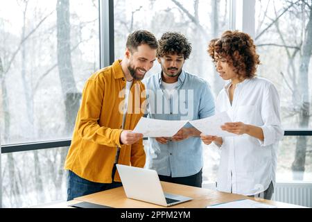 Creative business team. Positive multiracial partners gathered in office, confident businesspeople discuss new project, creative ideas, promotion strategy, analyze financial risks and profits, smile Stock Photo