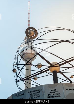 Famous Berlin Television Tower, observation Tower with world clock and plantes sculpture in front, view from low angle during sunset, clear sky Stock Photo