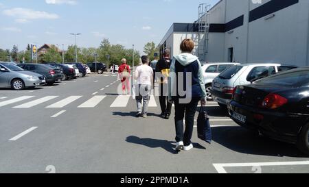 Belgrade, Serbia - May 20, 2020: A long line outside the LIDL, as the store took social distance measures during the COVID-19 pandemic. People stand apart from each other.Parking and crowd of people Stock Photo