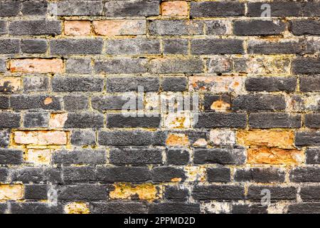 Old and worn black brick wall. Background texture. Stock Photo