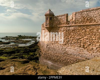 Old castle walls in Cadiz, Spain during cloudy sky Stock Photo