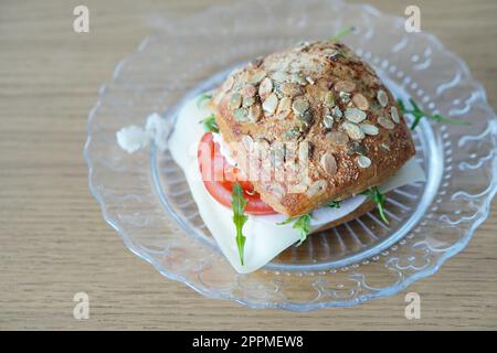 A freshly-prepared wheat sandwich filled with tomato and arugula Stock Photo