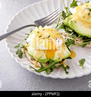 Healthy egg benedict sandwich with avocado and arugula, breakfast idea Stock Photo