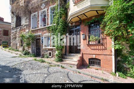 Cobblestone alley with beautiful old traditional red bricks houses in Balat district, on a summer day, Istanbul, Turkey Stock Photo