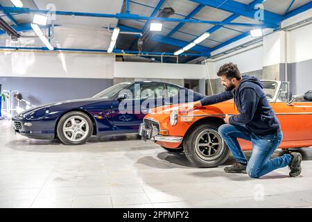 detailing, wash and cleaning of old and new cars in a car studio Stock Photo