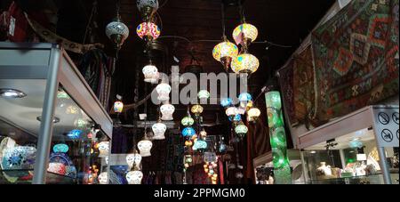 Traditional vintage Turkish lamps over light background in the night. Colored glass lamps and shades on the market in Sarajevo, Bosnia and Herzegovina. Sale of souvenirs in the market. Stock Photo