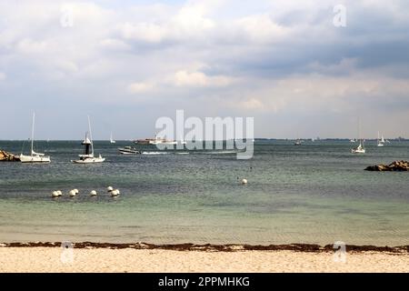 Many sailboats on a sandy beach in Germany with some beach chairs. Stock Photo