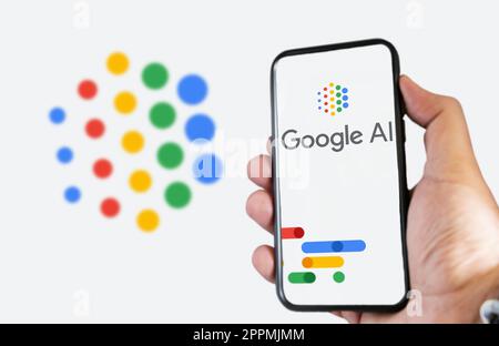 A hand holding a phone with the Google AI logo on the screen Stock Photo