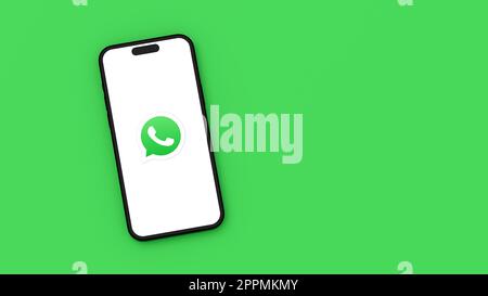 Whatsapp Logo on Mobile Phone Screen on Green Background with Copy Space Stock Photo