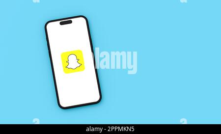 Snapchat Logo on Mobile Phone Screen on Blue Background with Copy Space Stock Photo