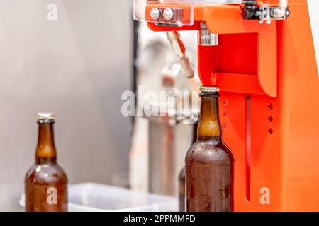capping beer bottles in a brewery Stock Photo
