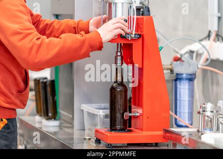 capping beer bottles in a brewery Stock Photo