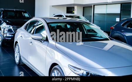 Car parked in luxury showroom. Car dealership office. New car parked in modern showroom. Car for sale and rent business concept. Automobile leasing and insurance concept. Electric vevicle for rent. Stock Photo