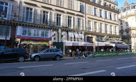 Paris, France - January 01, 2022: St-Honore Street. Citizens are sitting in the cafe. On the sidewalks are pedestrians Stock Photo