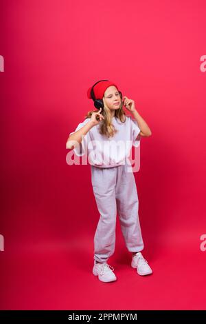 Child music concept. Teenager girl dances in rhythm of melody, listens song in headphones Stock Photo