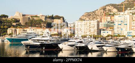 Monte Carlo, Monaco - Port Hercule with luxury yachts,  boats, and scenery skyline Stock Photo