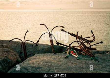 Old rusty anchors on the beach Stock Photo