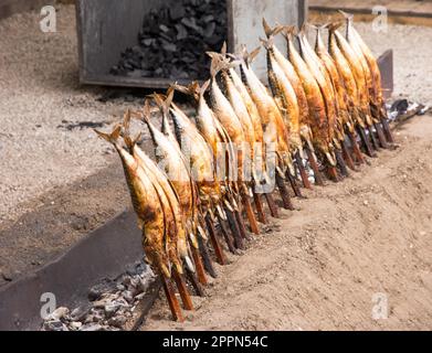 Steckerlfisch (grilled fish on a stick) - traditional meal seen on Oktoberfest in Munich Stock Photo