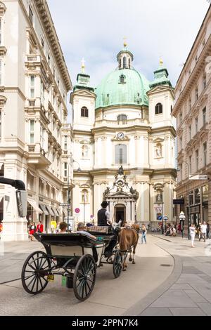 VIENNA, AUSTRIA - AUGUST 28: Tourists in a horse-drawn carriage called Fiaker at Peterskirche church in Vienna, Austria on August 28, 2017 Stock Photo