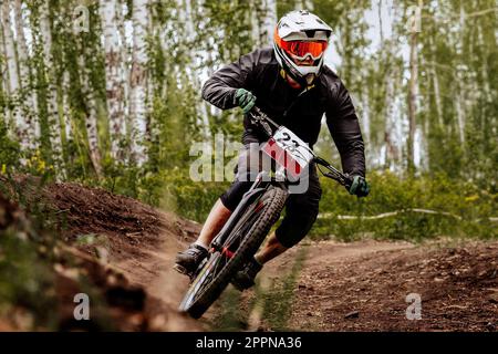 racer athlete riding cornering turn downhill race, sports summer games in mountain bike Stock Photo