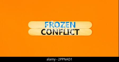 Frozen conflict symbol. Concept words Frozen conflict on beautiful wooden stick. Beautiful orange table orange background. Business and Frozen conflic Stock Photo