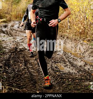 male runner running on iimpassability dirt road autumn marathon, cross-country running race Stock Photo