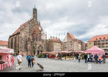 NUERNBERG, GERMANY - SEPTEMBER 5: Tourist at the Frauenkirche in Nuernberg, Germany on September 5, 2015. The church is a brick gothic architecture Stock Photo