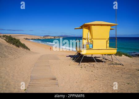 Moro beach in the Corralejo Natural Park in the north of Fuerteventura island in the Canaries, Spain - Yellow lifeguards tower on stilts on front of t Stock Photo