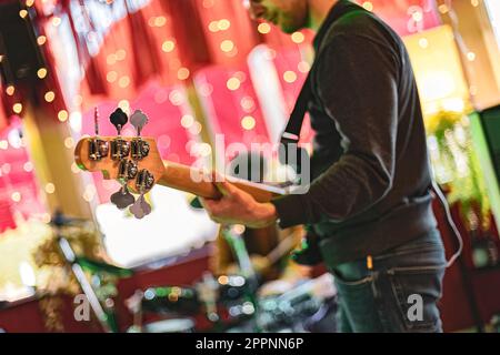Close up shot of a bassist fully immersed in the music during a live performance in a music venue. Stock Photo